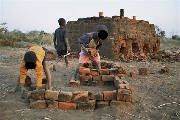 Unidentified children carry bricks from an oven on August 17, 2006 in Mphandula village, about 30 miles outside Lilongwe, Malawi. Mphandula is a poor village in Malawi, without electricity or clean water. Nobody owns a car or a mobile phone. Most people live on farming. About 7000 people reside in the village and the chief estimates that there are about five-hundred orphans. Many have been affected by HIV/Aids and many of the children are orphaned. A foundation started by Madonna has decided to build an orphan center in the village through Consol Homes, a Malawi based organization. Raising Malawi is investing about 3 million dollars in the project and Madonna is scheduled to visit the village in October 2006. Malawi is a small landlocked country in Southern Africa without any natural resources. Many people are affected by the Aids epidemic. Malawi is one of the poorest countries in the world and has about 1 million orphaned children.
